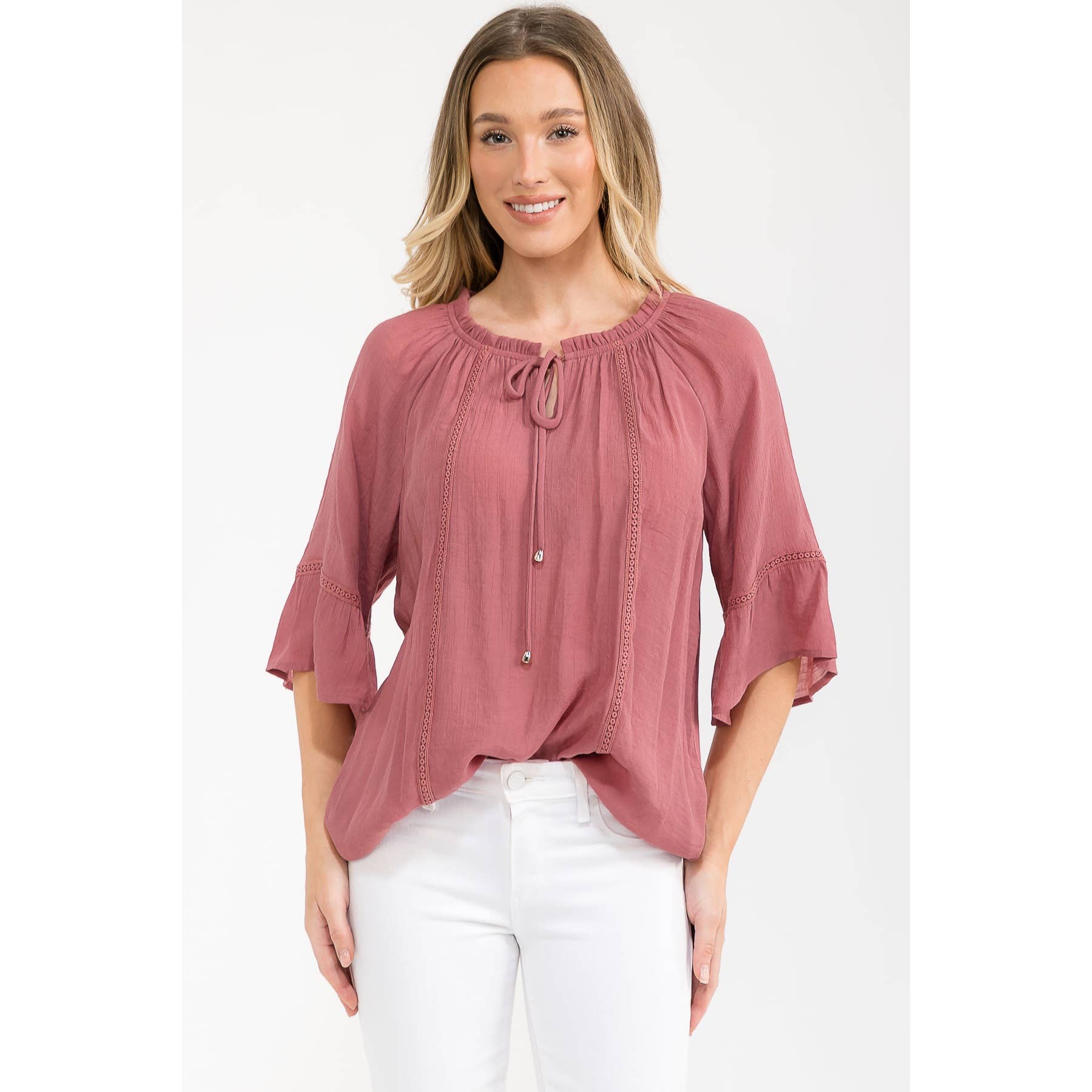 Peasant top with a round neckline, front tie, bell sleeves, and crochet trim in Brandy shade. 