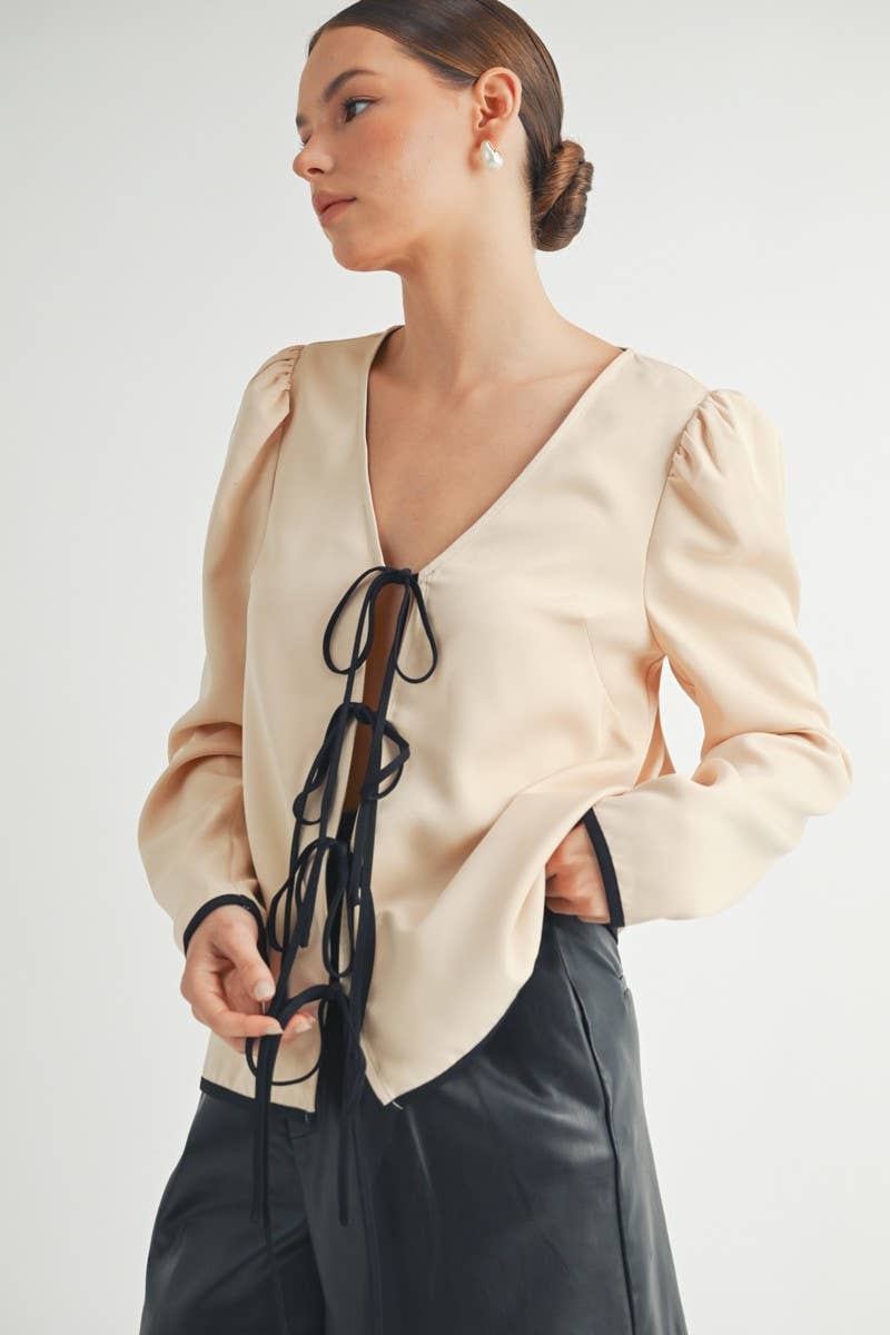 Puff-sleeve blouse with a deep V-neckline, contrast trim, and a tie-front detail.

