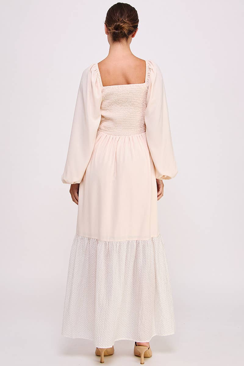 Back of a pale blush maxi dress with a square neckline, smocked bodice, long balloon sleeves, and contrasting ivory Shimmer hem.